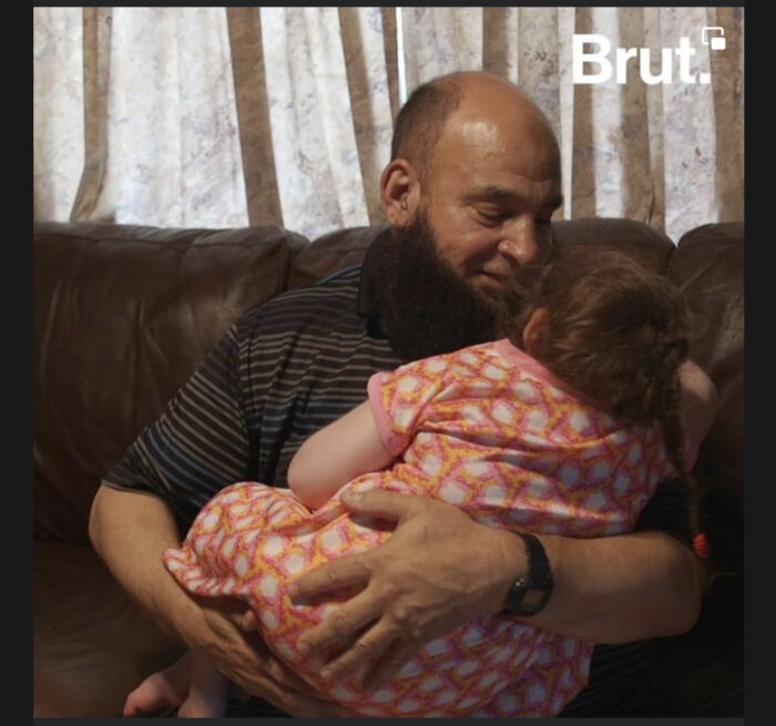 Mann mit Bart mit unheilbar krankem Kind auf dem Arm